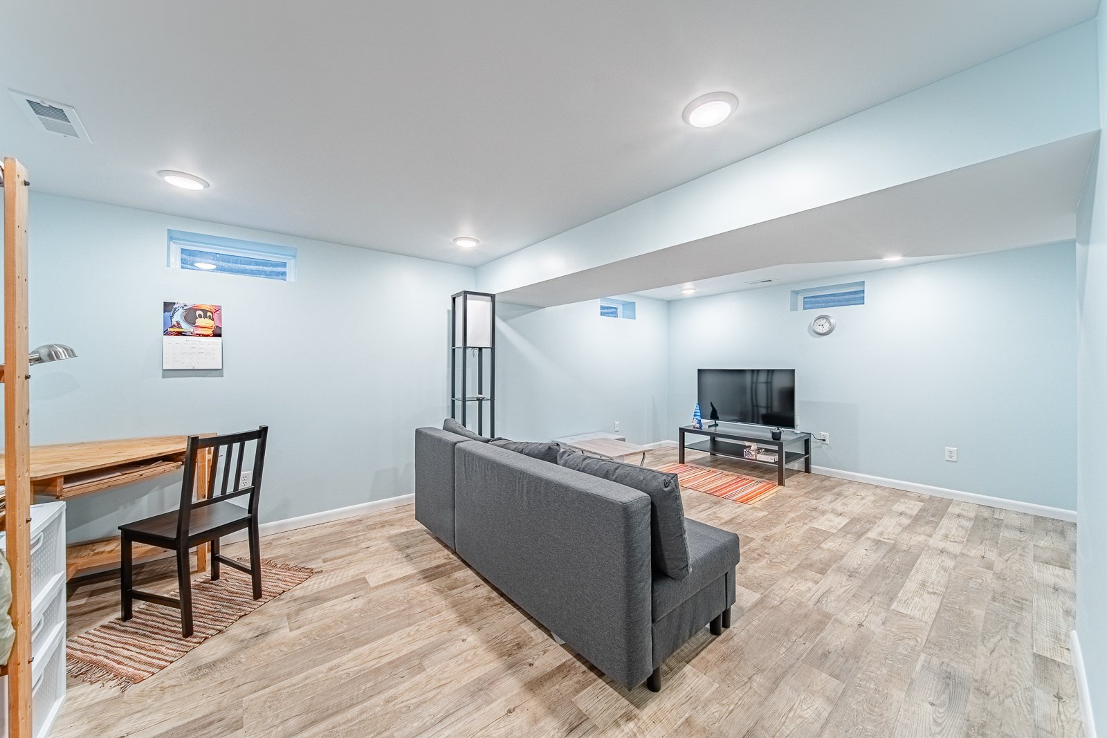 basement-media-room-with-workspace-and-sofa