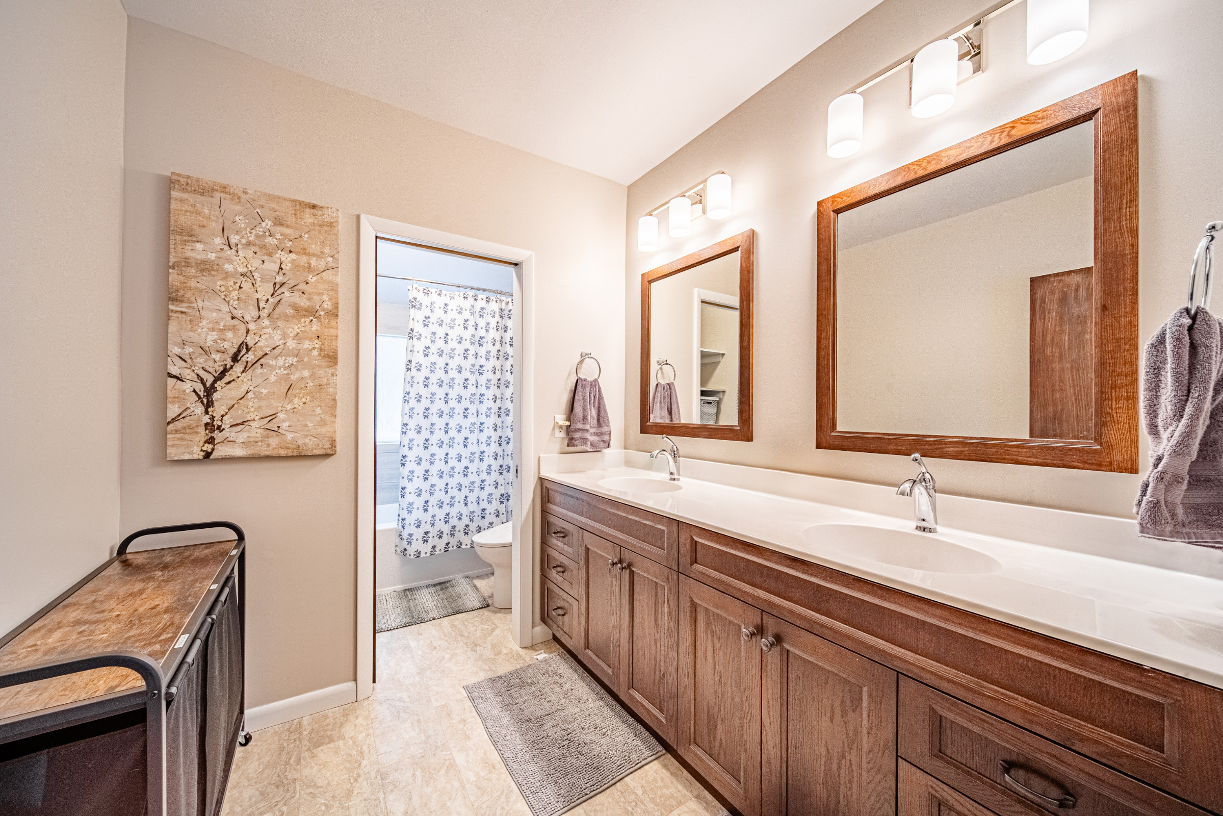 Discover the transformation of a West Lafayette bathroom, now featuring double sinks, tiled walls, and efficient storage for family use.