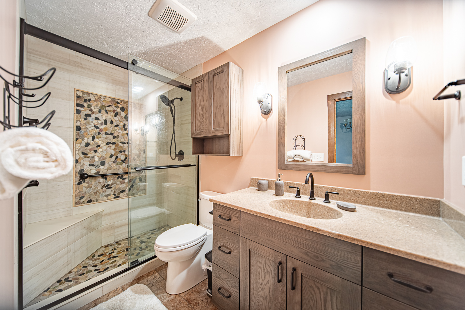 This hall bathroom remodel in Lafayette combines functionality and style with modern fixtures, a glass-enclosed shower, added storage, and future-proof features.