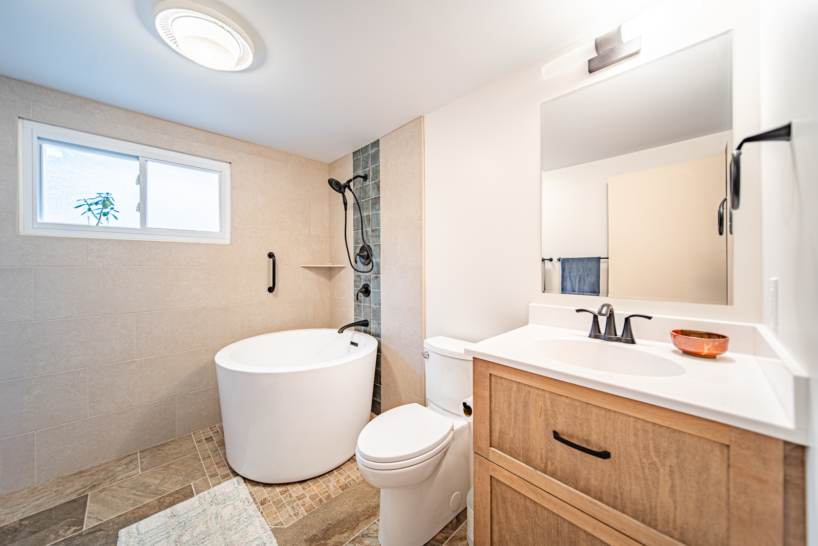 A Lafayette hall bathroom remodel featuring a Japanese-style soaking tub, glass shower panel, custom cabinetry, and elegant tile accents for a spa-like retreat.