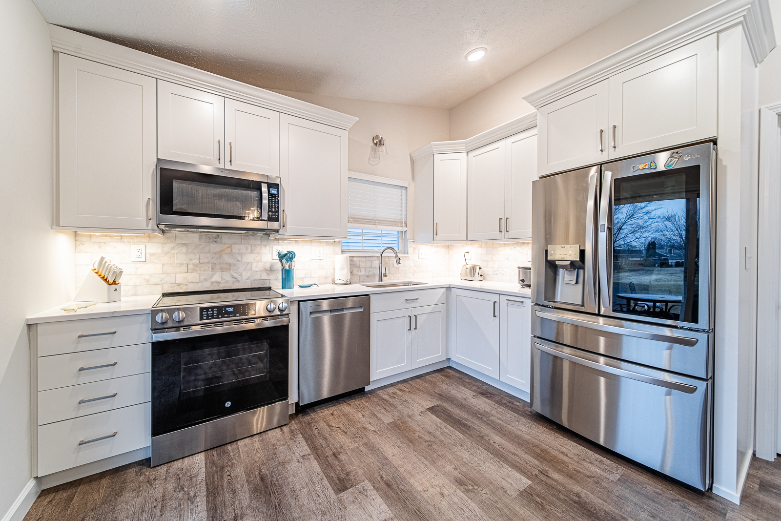 A beautiful kitchen remodel in Lafayette featuring tall white shaker cabinets, quartz countertops, and custom backsplash for a bright, functional space.
