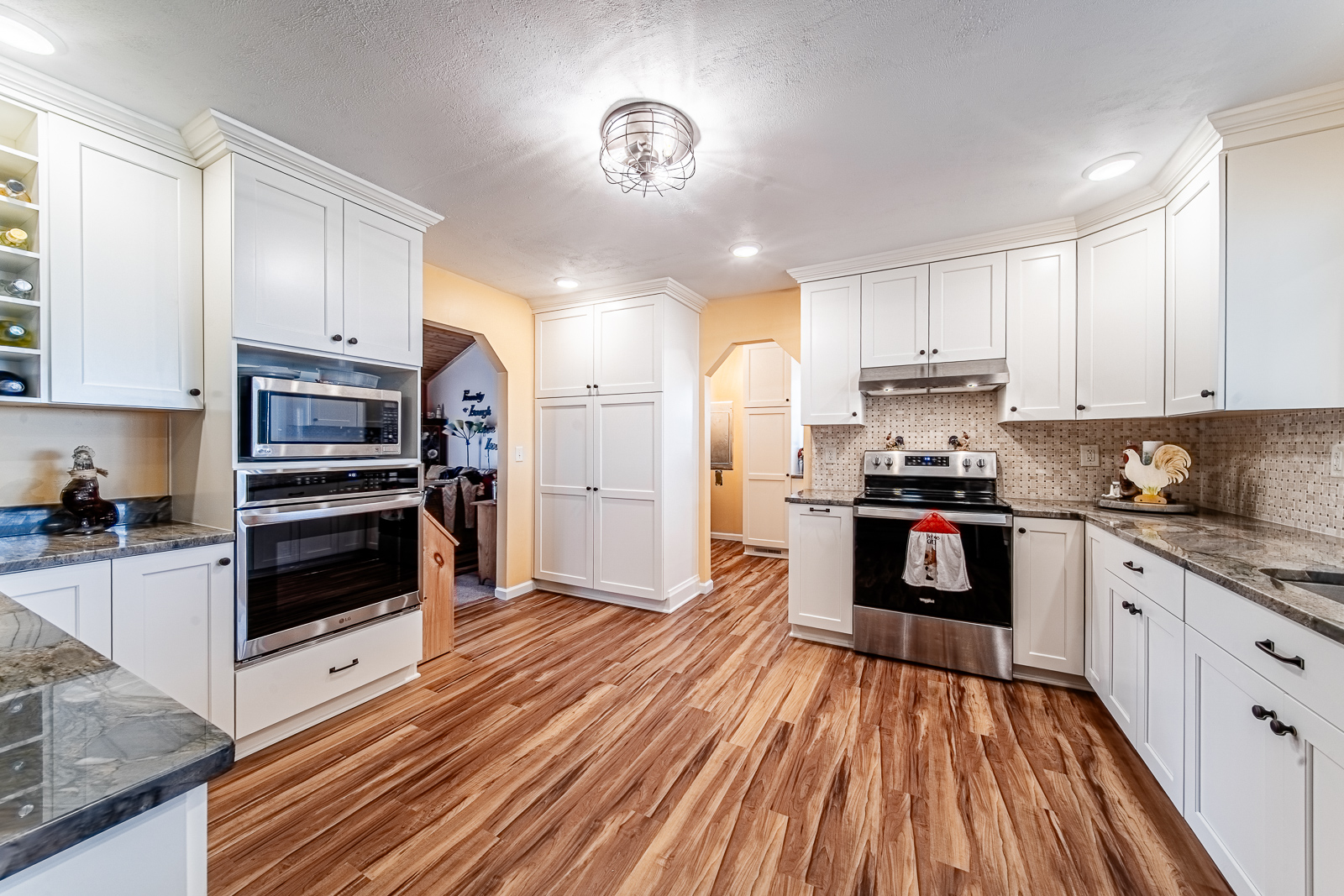 A cozy, updated kitchen remodel in Lafayette featuring warm cream cabinetry, rich stone countertops, and thoughtful storage — all designed for everyday comfort.