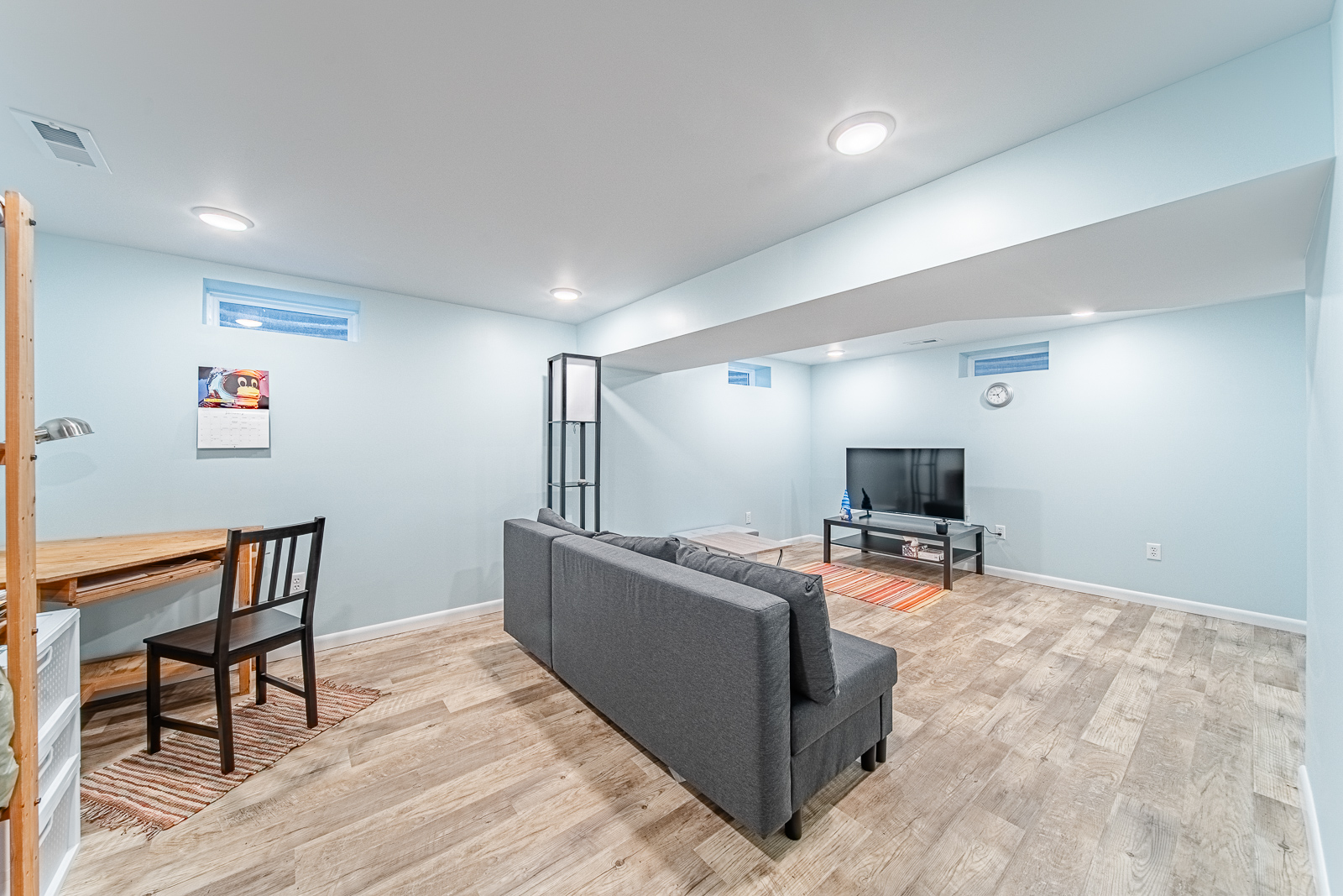 basement-media-room-with-workspace-and-sofa
