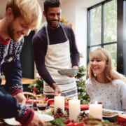 Friends and family gathered around a kitchen table decorated for Christmas, illustrating a warm, inviting holiday atmosphere in a well-designed kitchen.