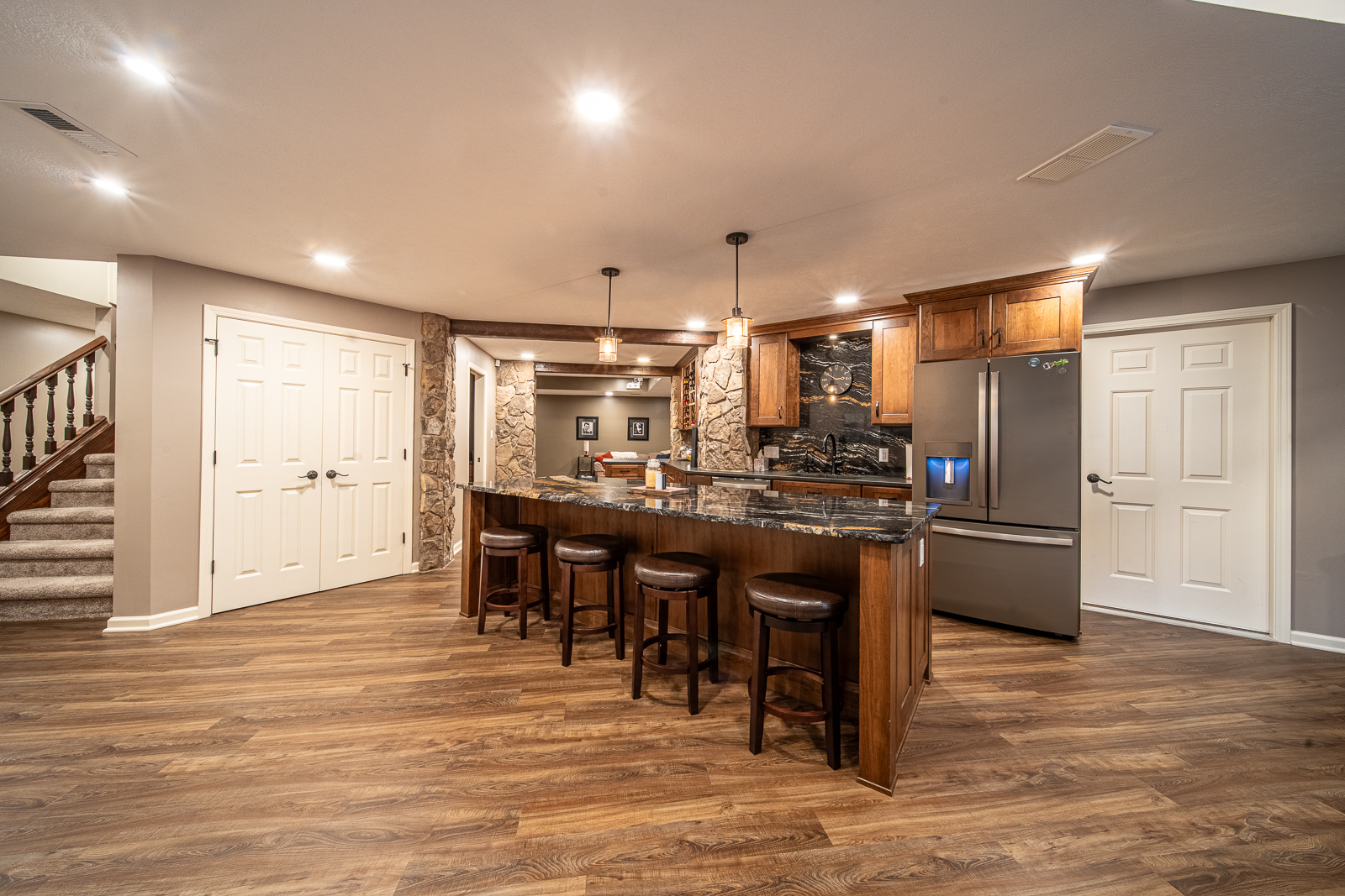 Spacious basement kitchen with island and bar seating in Ripple Creek Drive remodel.