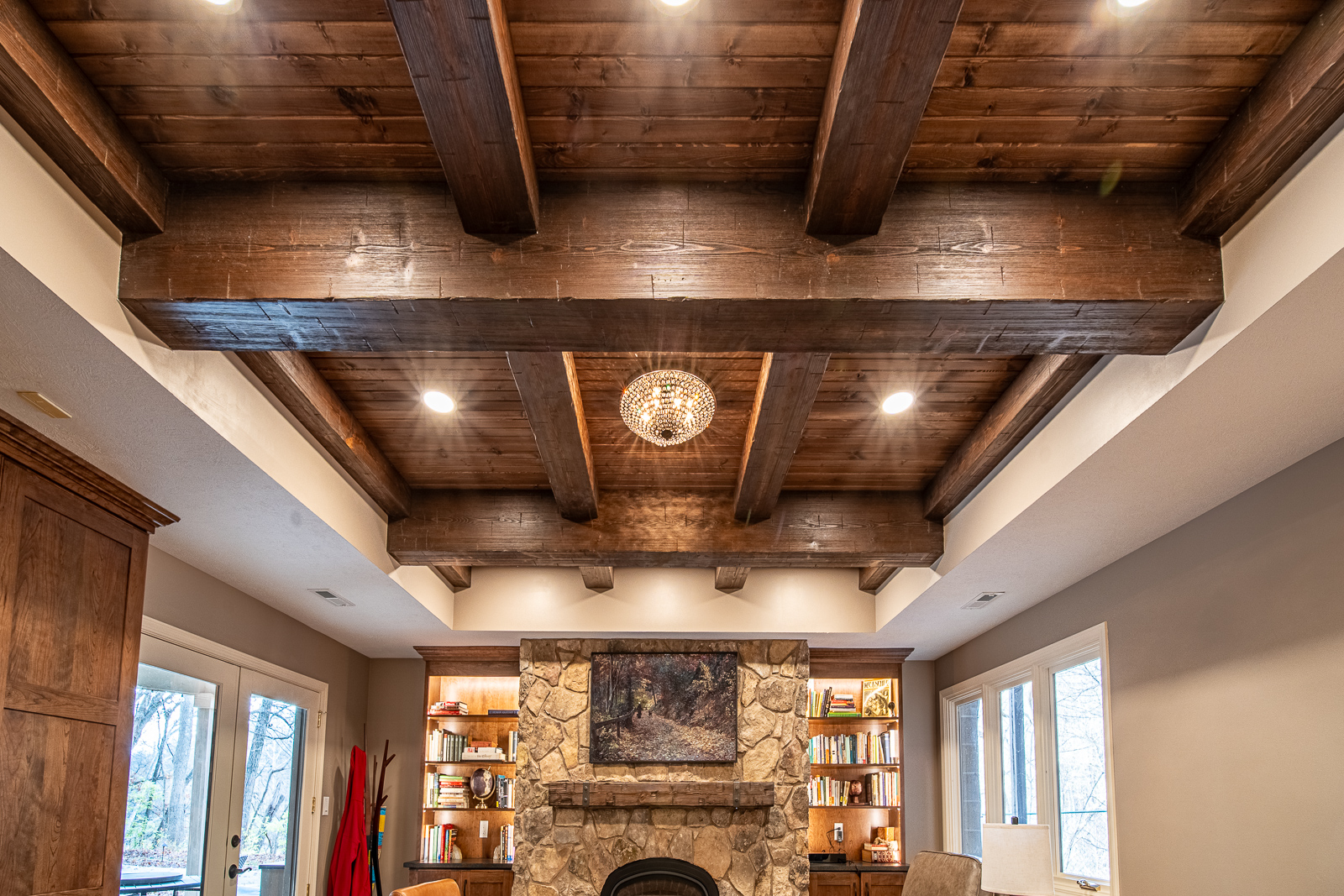 Elegant tray ceiling with rustic wood beams in Ripple Creek Drive basement remodel.