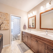 Newly renovated West Lafayette bathroom with double sinks, tiled bath, and added storage for a family home.